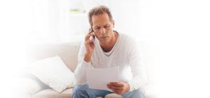 Man on the phone looking at paper