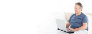 Picture of a caregiver searching on his laptop for support