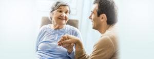 Senior woman communicating with her adult son. Focus is on senior woman.